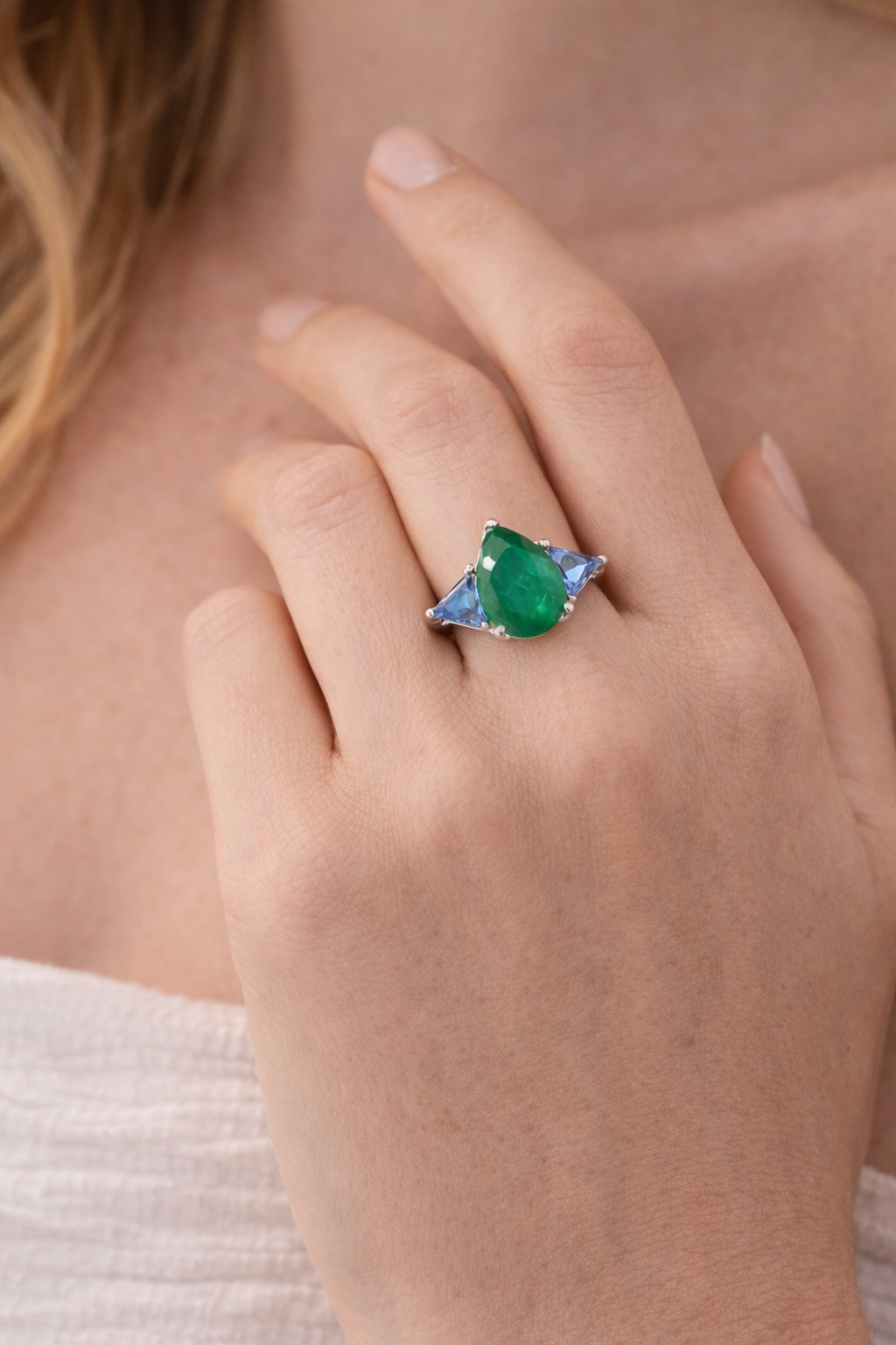 Close-up of a hand wearing a ring with a green gemstone.