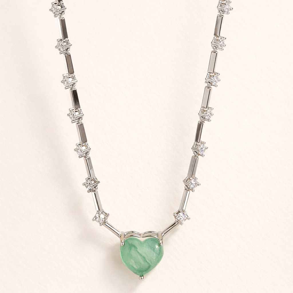 Necklace with a heart-shaped green gemstone pendant on a white background