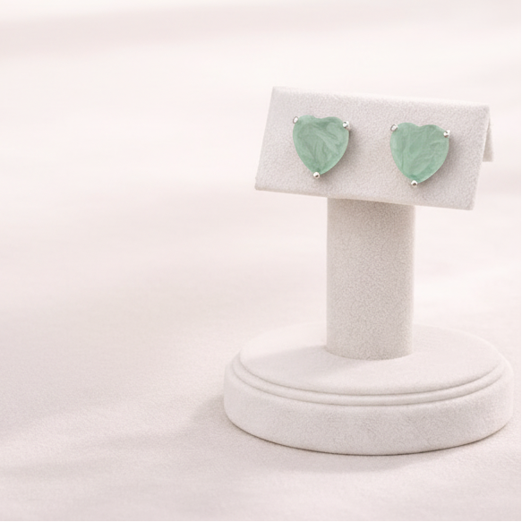 Mint green heart-shaped earrings on a white background