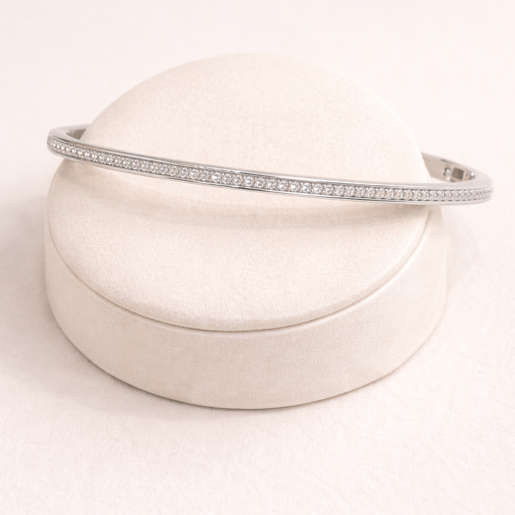 Silver headband on a round beige cushion with a white background