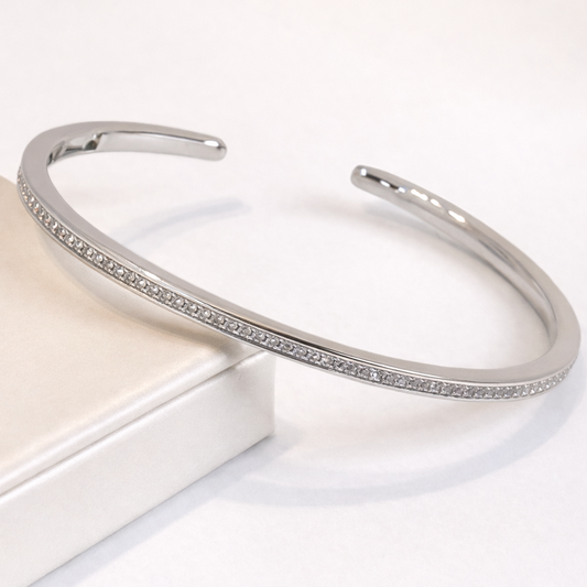 Silver bracelet with small stones on a white surface