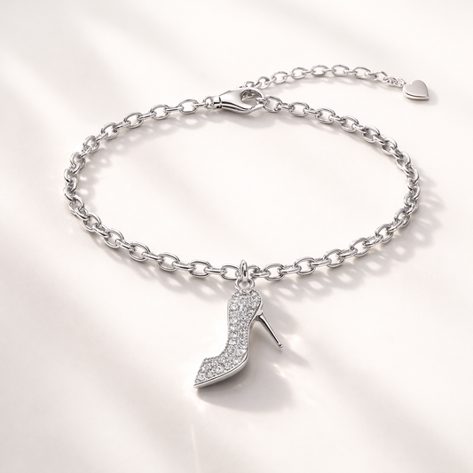 Silver bracelet with high heel shoe charm on a light gray background