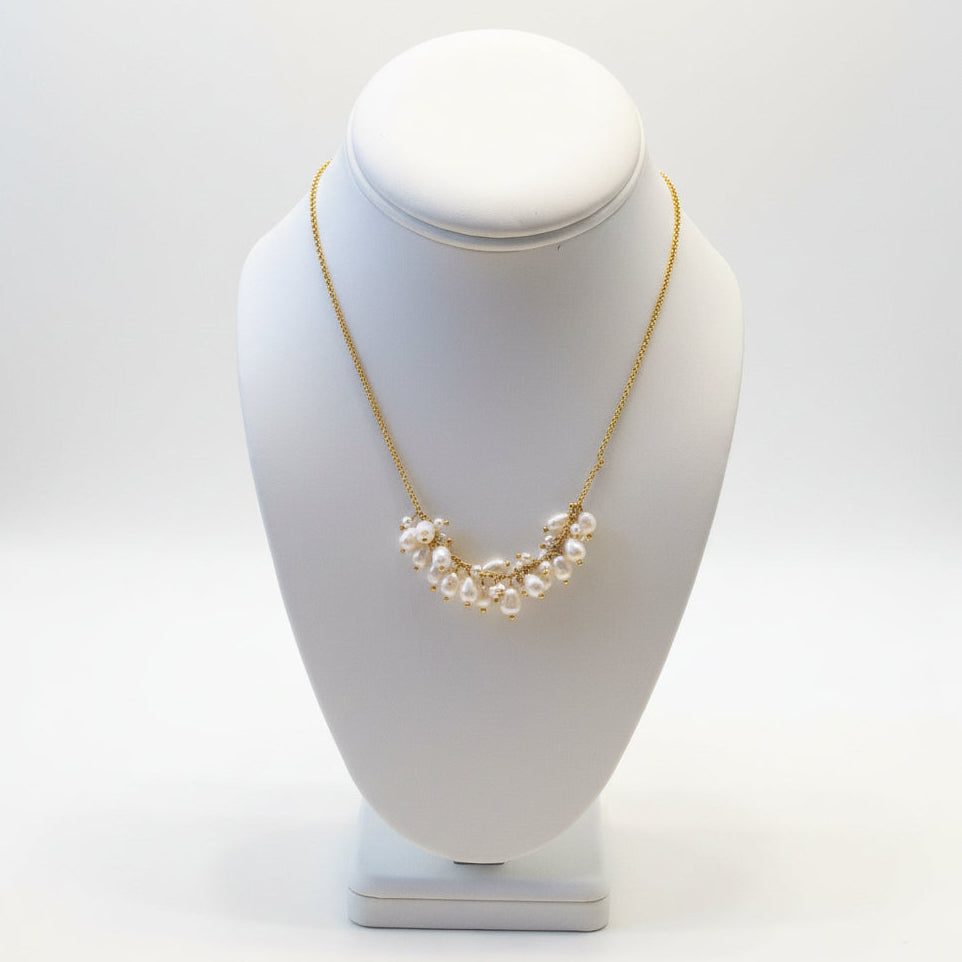 Necklace with pearls on a white mannequin bust against a neutral background