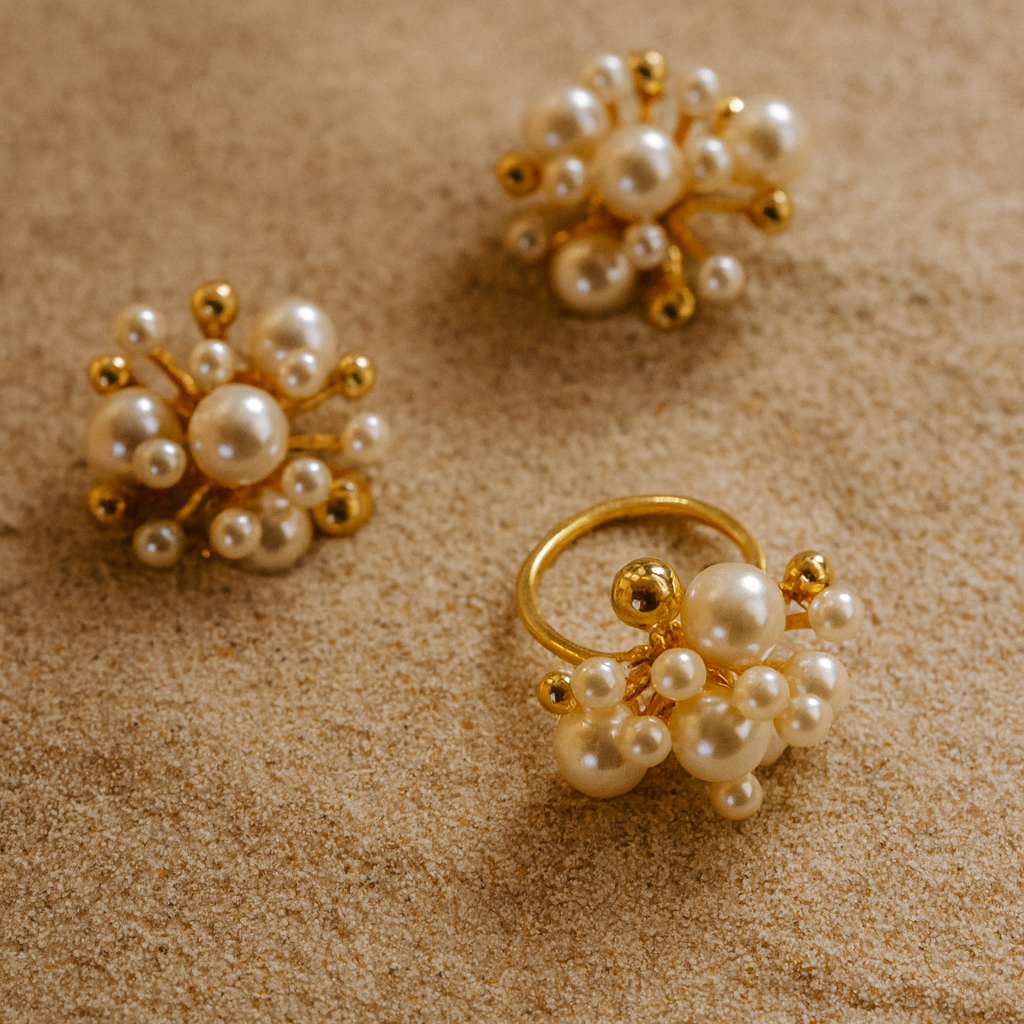 Pearl and gold earrings on a beige surface