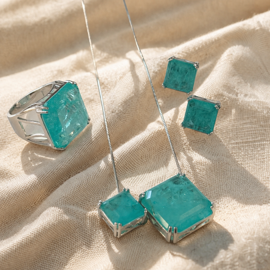 Turquoise jewelry set with ring, necklace, and earrings on a beige fabric background