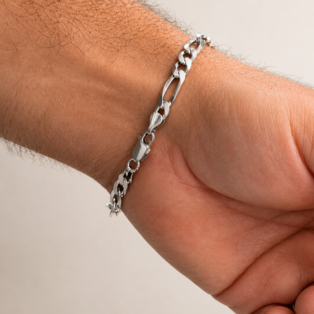Silver chain bracelet on a wrist against a neutral background