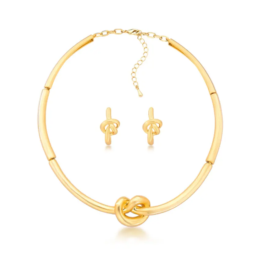 Gold necklace and earrings set on a white background