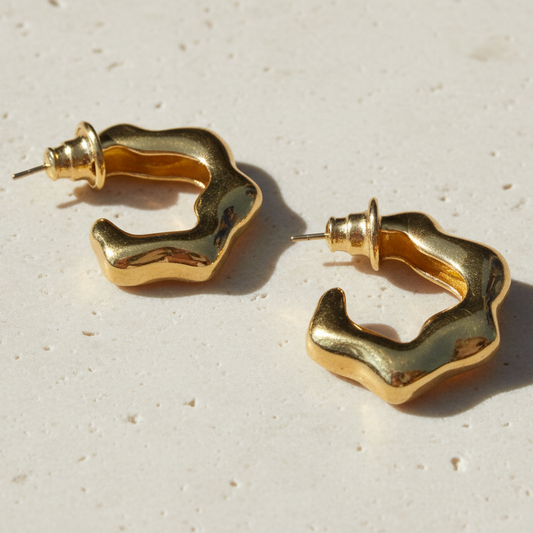 Gold hoop earrings on a light gray background