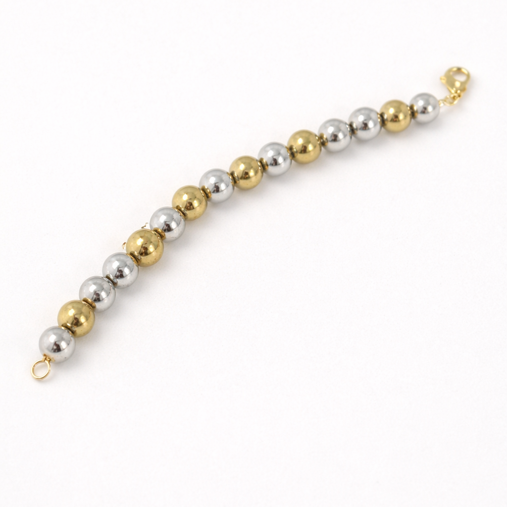 Bracelet with alternating gold and silver beads on a white background