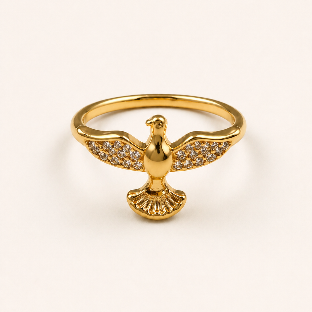 Gold ring with a dove design on a light beige background