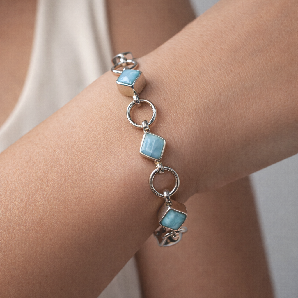 Bracelet with turquoise stones on a wrist against a neutral background