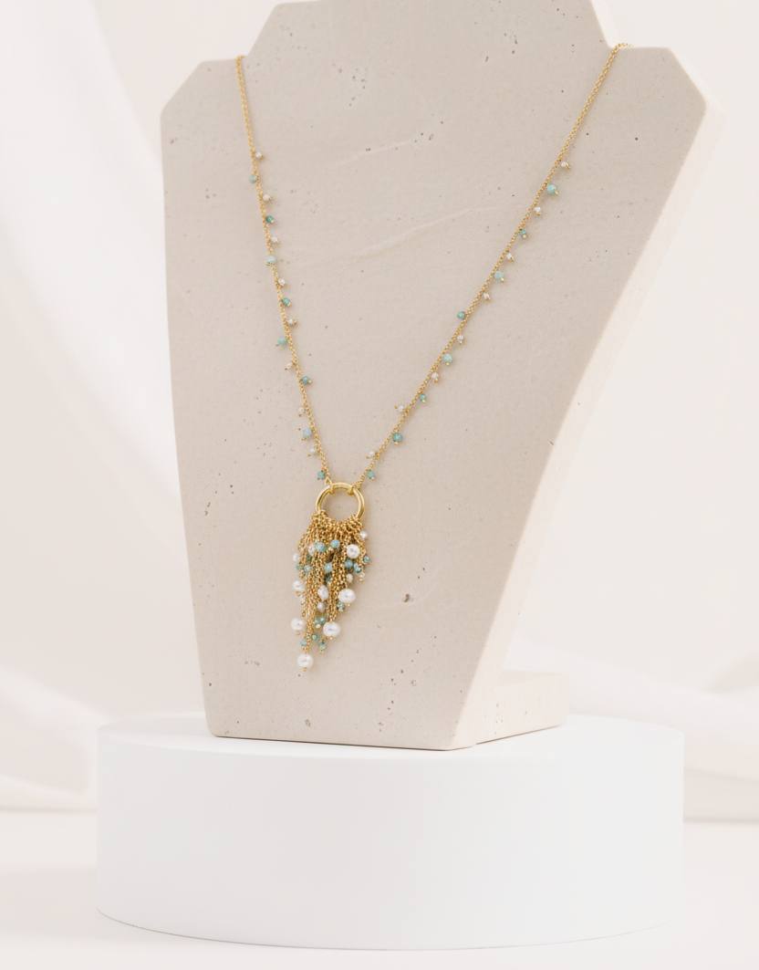 Necklace with a decorative pendant on a black velvet stand against a white background