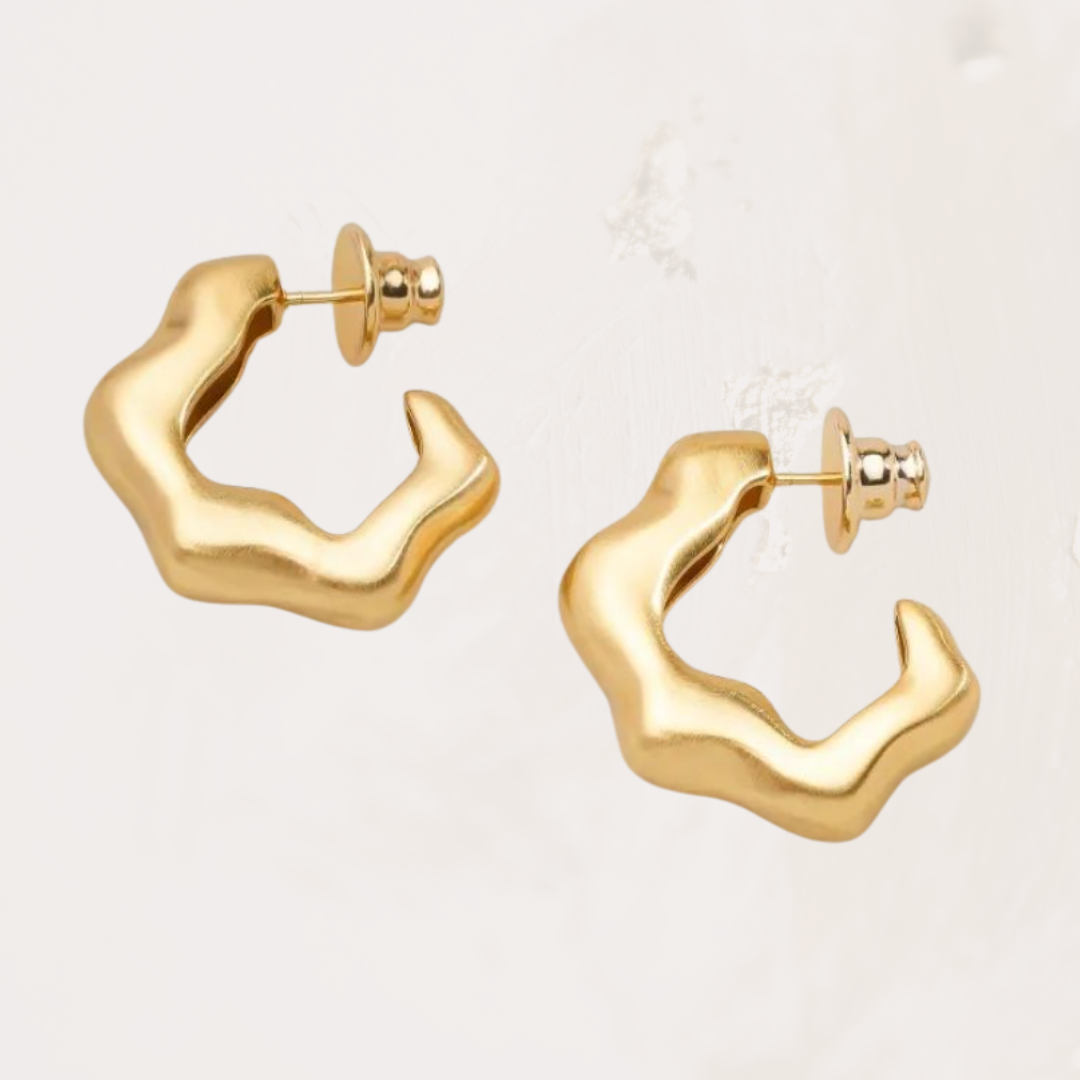 Gold hoop earrings on a light background