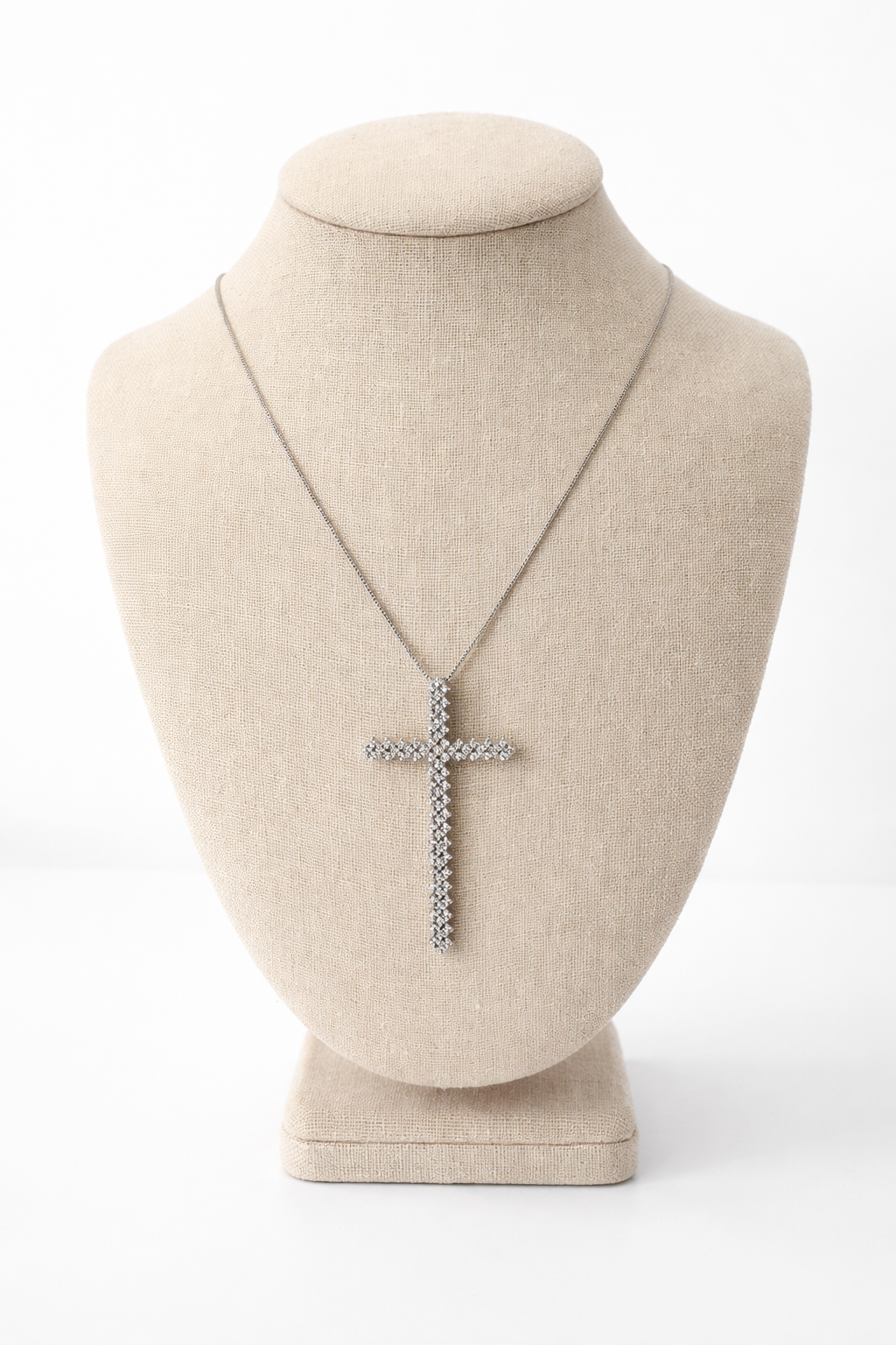 Necklace with a cross pendant on a mannequin bust against a white background