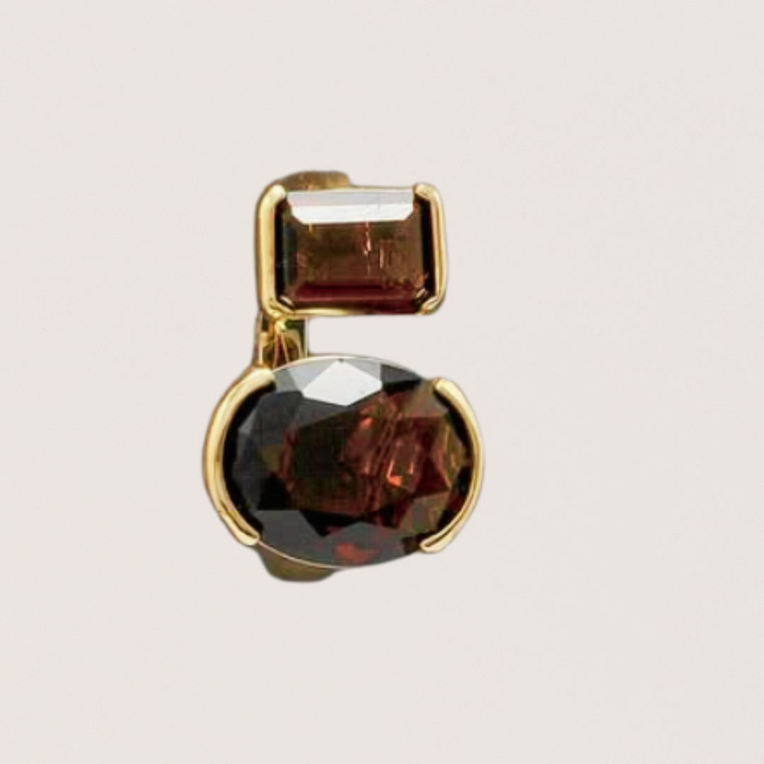 Gold earring with brown gemstones on a light gray background