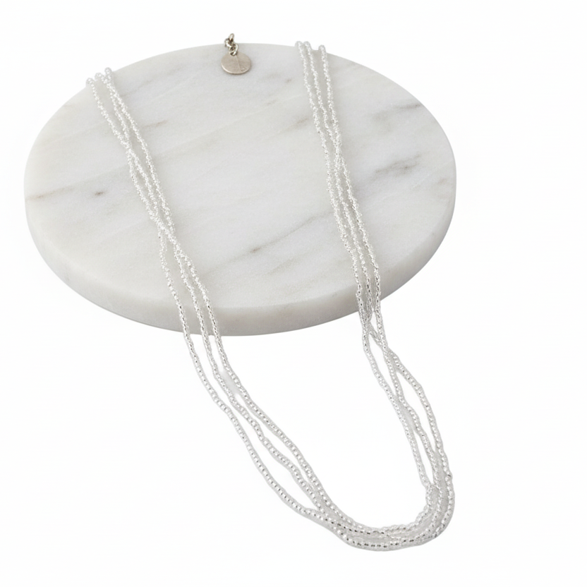 Silver necklace on with a white background
