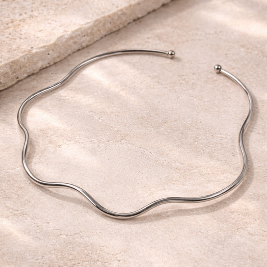 Silver necklace on a beige stone surface