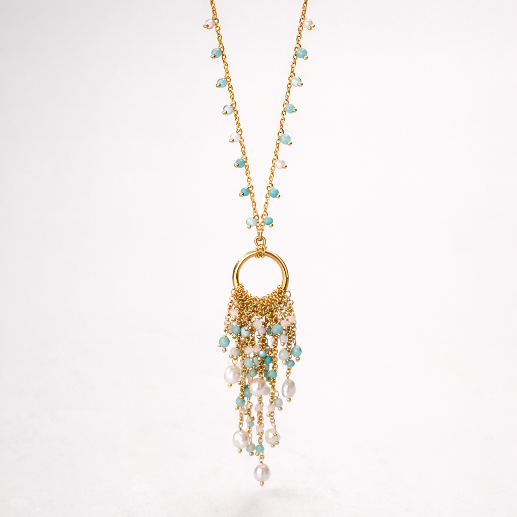 Gold necklace with turquoise and pearl beads on a white background